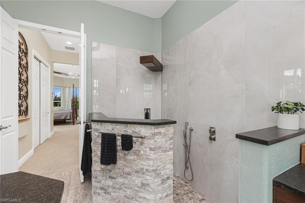 Ensuite bathroom with a walk in shower and light carpet