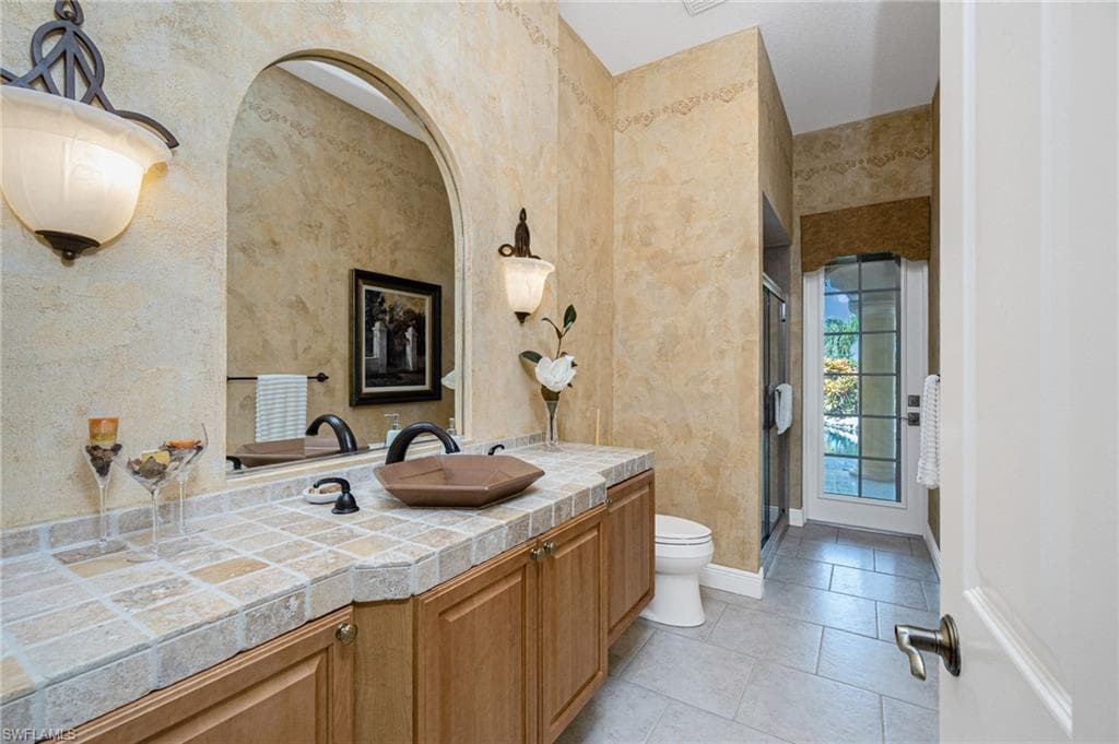 Bathroom with vanity, a stall shower, and light tile patterned flooring