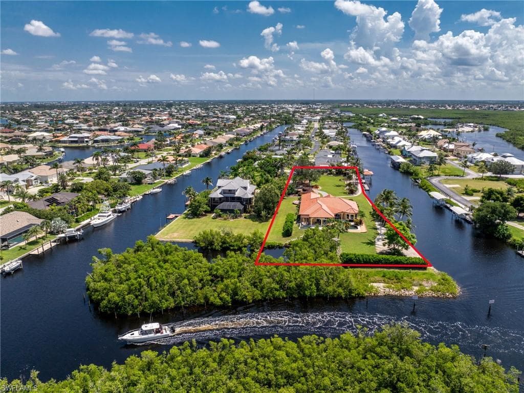 Aerial perspective of suburban area featuring property boundaries highlighted and a large body of water