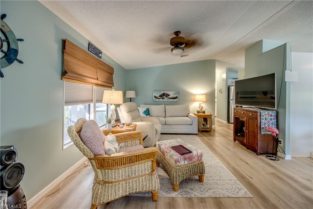 Living room featuring light wood-style floors and a ceiling fan
