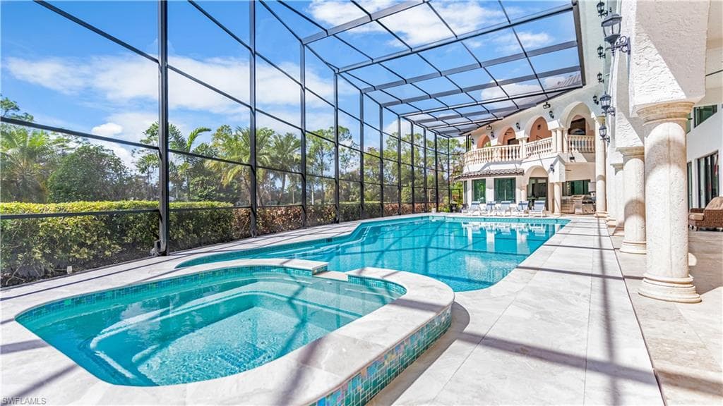 Combined pool / hot tub with a lanai, a patio area, and a balcony
