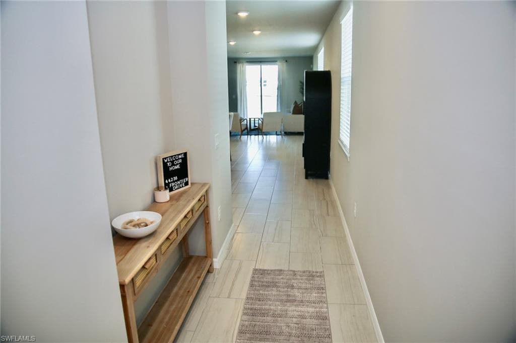 Corridor with baseboards and recessed lighting
