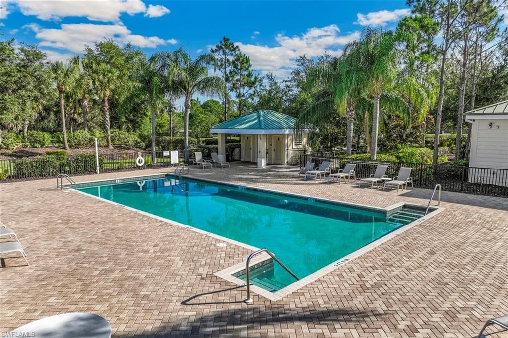 The property includes a rectangular swimming pool surrounded by a brick paver deck