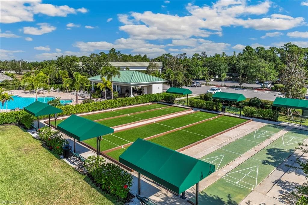 The property features bocce ball courts and shuffleboard courts, accompanied by shaded seating areas