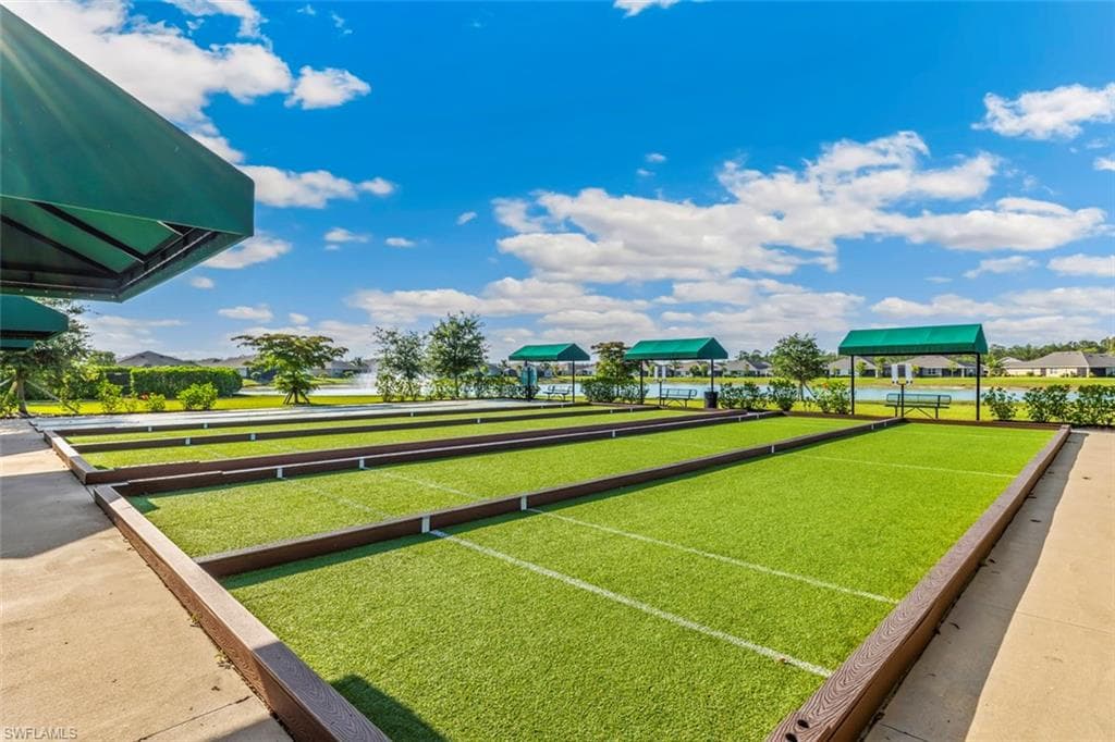 Outdoor recreation area featuring bocce ball courts with artificial turf and a covered seating area