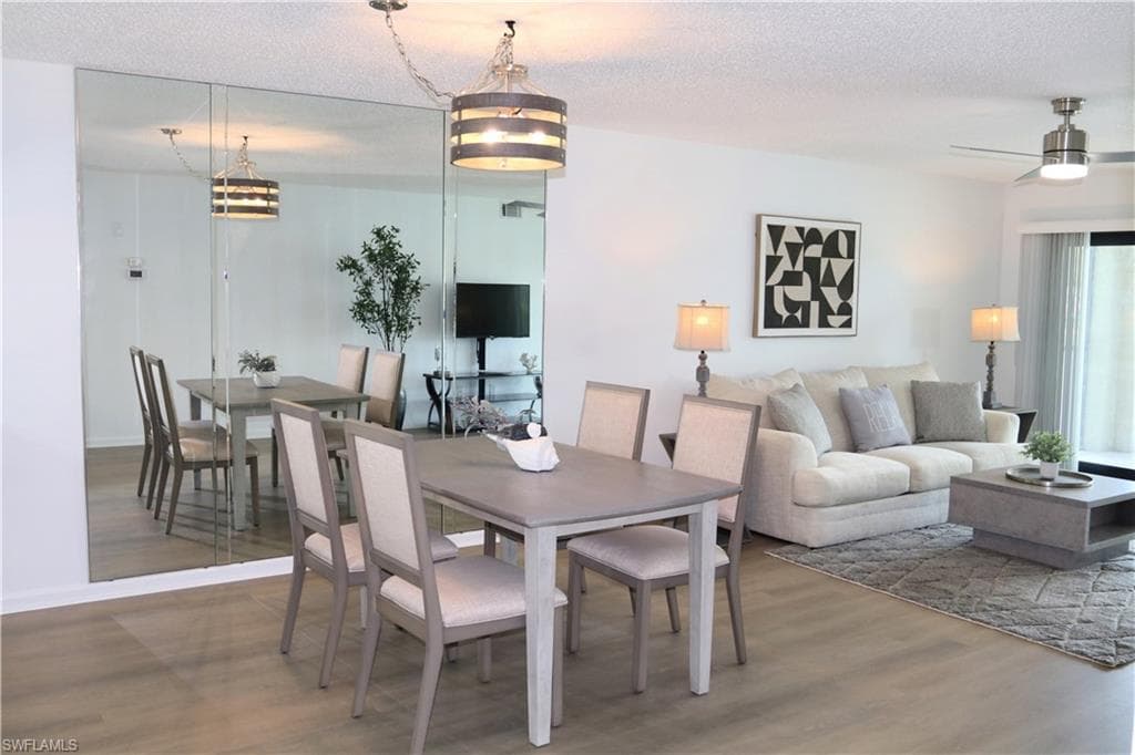 Dining space featuring a textured ceiling, wood finished floors, and a ceiling fan