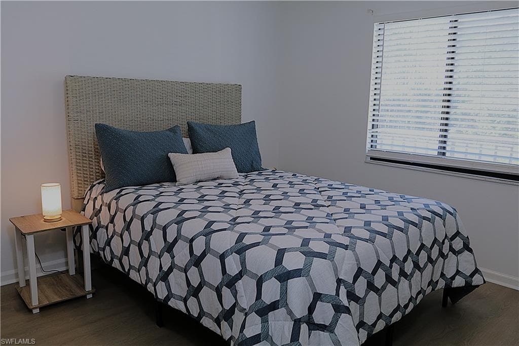 Bedroom with baseboards and dark wood-style floors