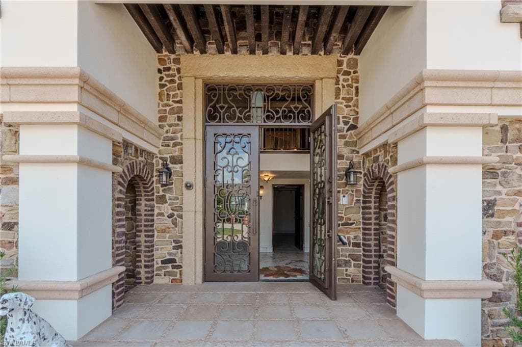 Entrance to property with stone siding and stucco siding