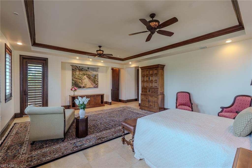 Bedroom featuring a tray ceiling, recessed lighting, ornamental molding, and ceiling fan