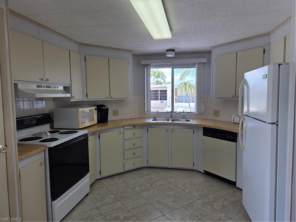 Bright, cheerful kitchen with stove, fridge, microwave, & dishwasher.