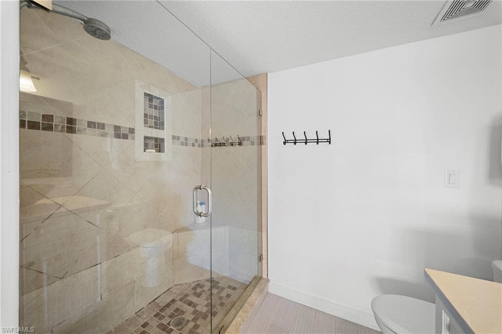 Full bath featuring a stall shower and vanity