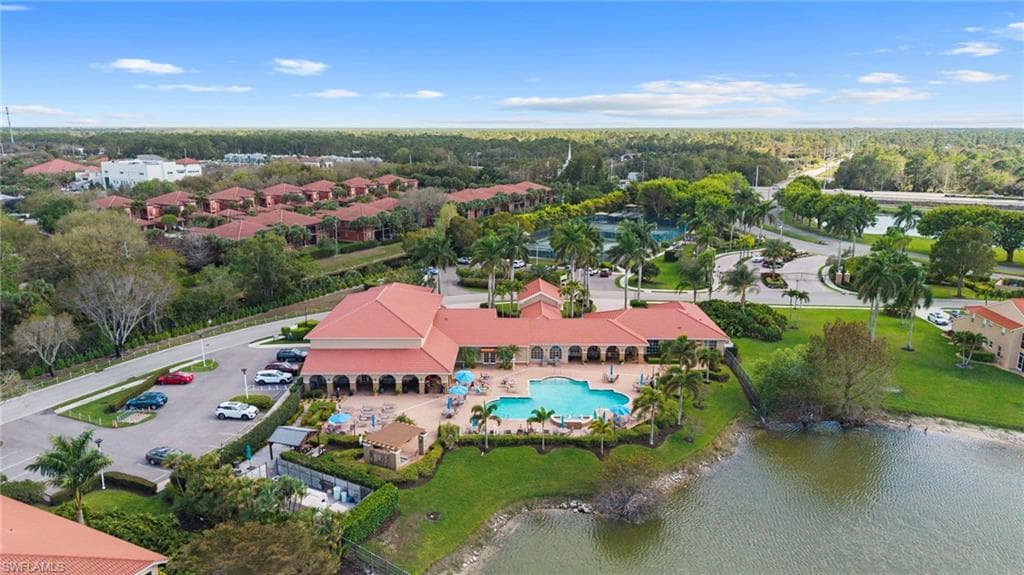 Aerial perspective of suburban area with a pool and a large body of water