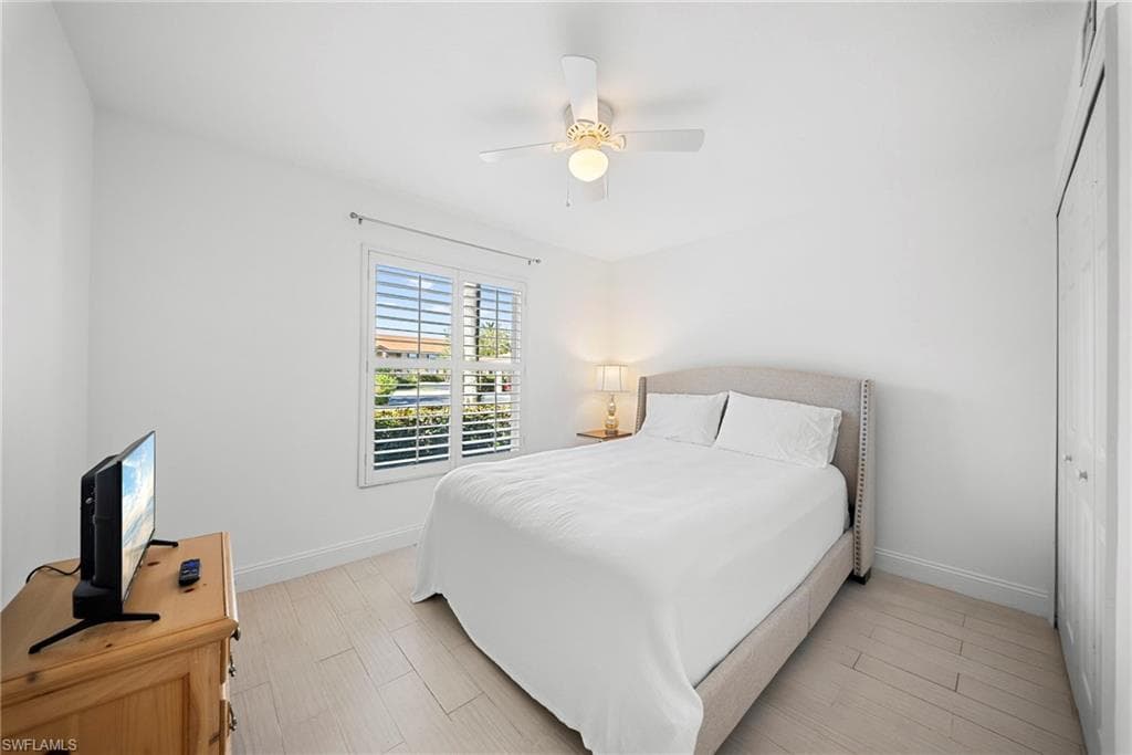 Bedroom with ceiling fan, wood finish floors, and a closet