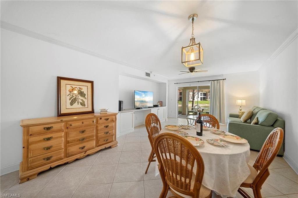 Dining space featuring ornamental molding, light tile patterned floors, and ceiling fan