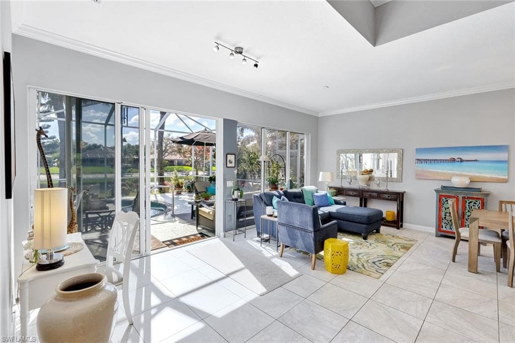 Open-concept interior featuring large format tile flooring, crown molding, and recessed lighting