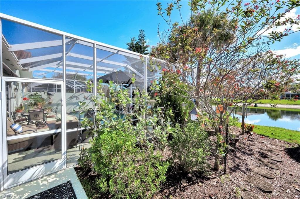 Screened-in outdoor living space featuring a concrete patio, a structured enclosure, and access to a manicured lawn