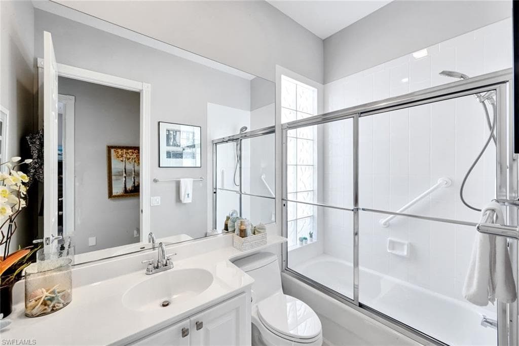 Full bathroom featuring a single vanity with an integrated sink, white countertop, white cabinetry, and an oversized wall mirror