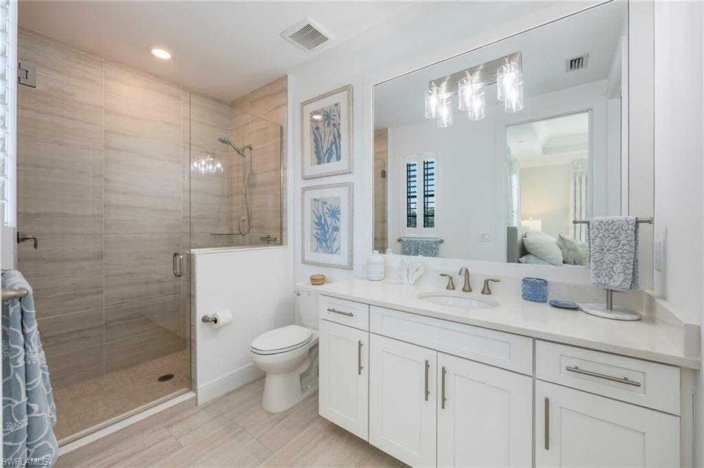 Ensuite bathroom featuring a shower stall and vanity