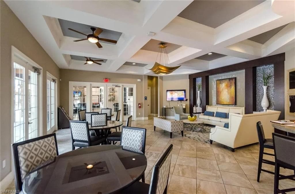 Dining room with coffered ceiling, a ceiling fan, and french doors