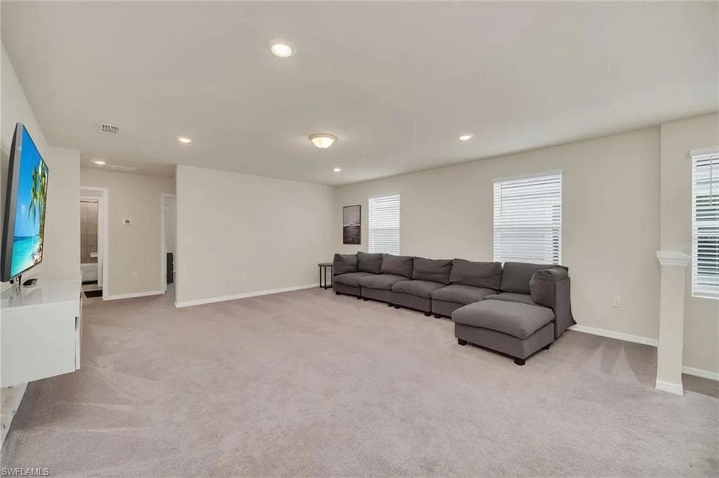 Living area featuring recessed lighting and light colored carpet