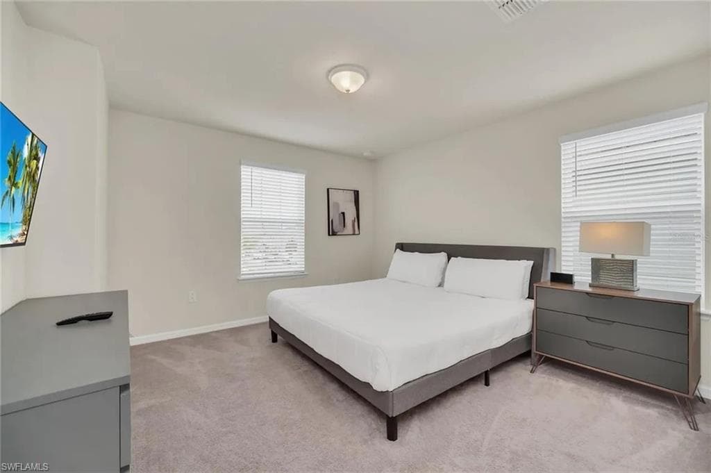 Bedroom featuring light colored carpet and baseboards