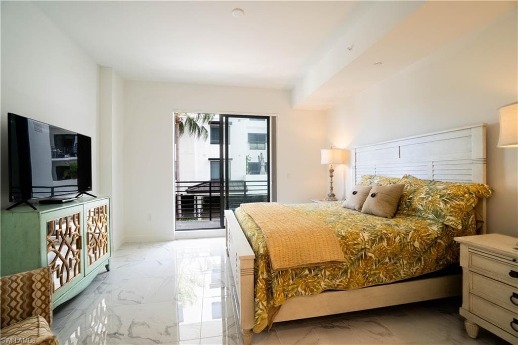 Bedroom featuring light marble finish flooring and access to outside
