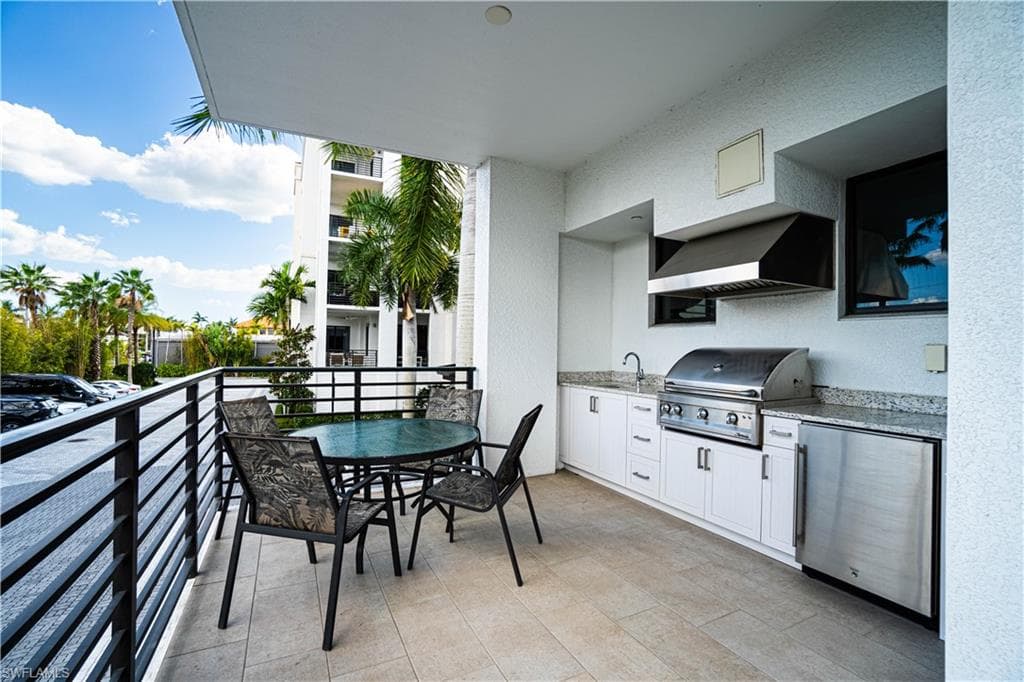 Balcony featuring an outdoor kitchen / dining area and a sink