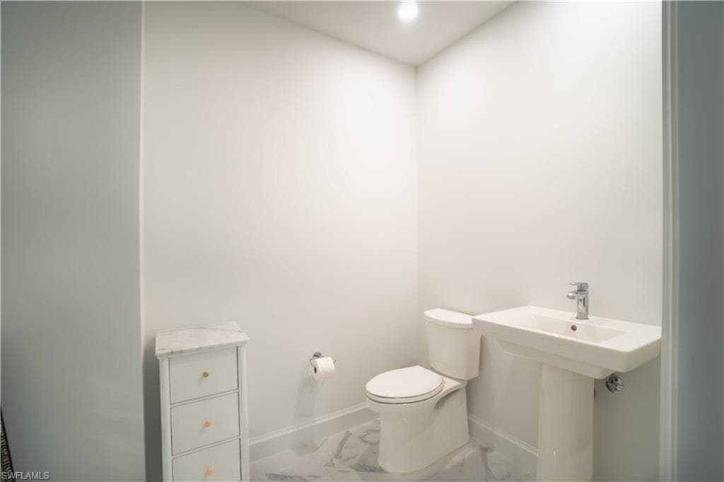 Half bathroom with recessed lighting and marble finish floorin