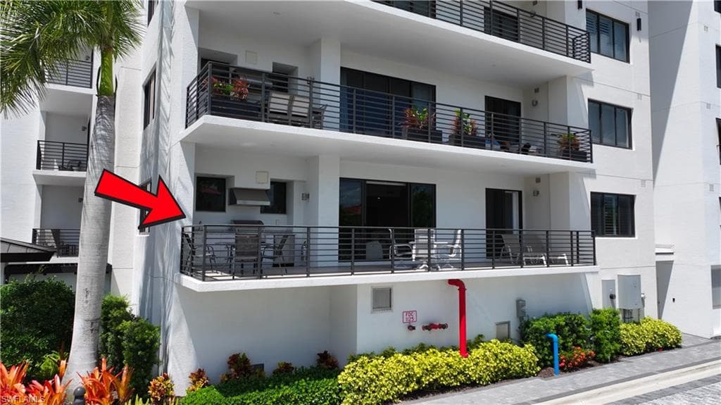 Balcony featuring a built-in outdoor grill, dark horizontal railings, and sliding glass doors