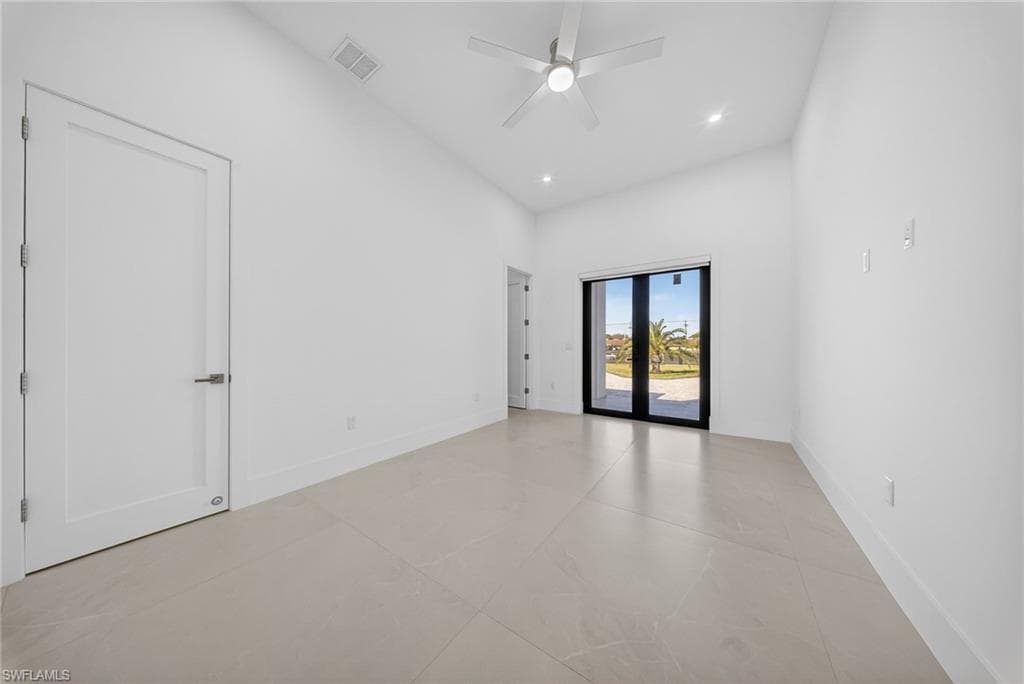 Empty room featuring a ceiling fan, a high ceiling, french doors, and recessed lighting