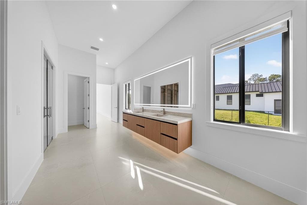 Full bath featuring vanity, plenty of natural light, and recessed lighting