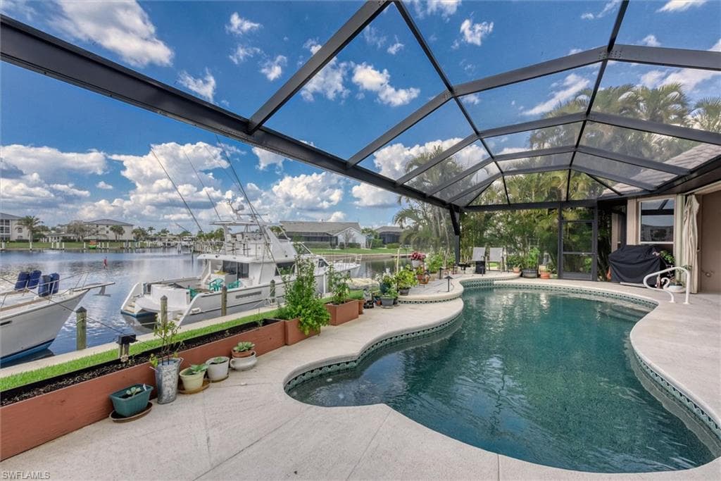 Swimming pool with a sunroom, a boat dock, a residential view, a patio, and grilling area