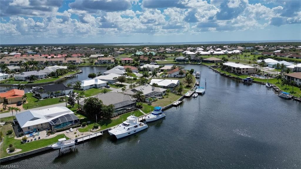 Aerial overview of property's location featuring a nearby body of water and nearby suburban area