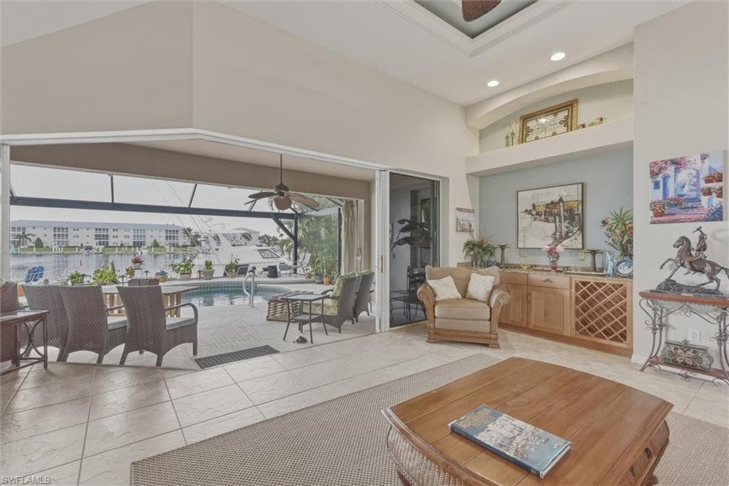 Living room with a sunroom, ceiling fan, a high ceiling, and recessed lighting
