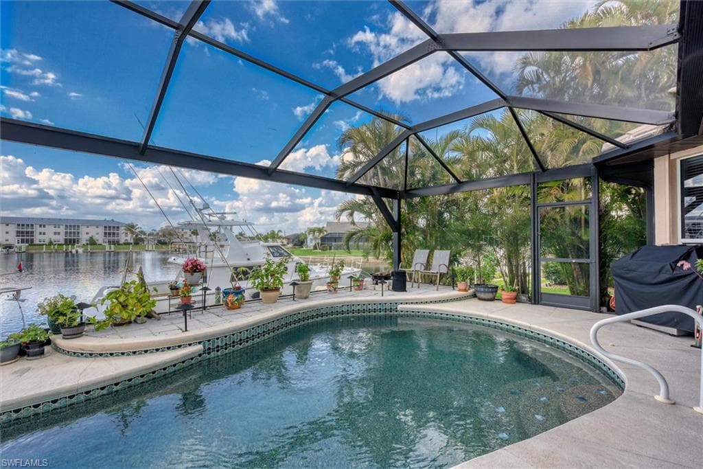 Swimming pool featuring glass enclosure and a patio area