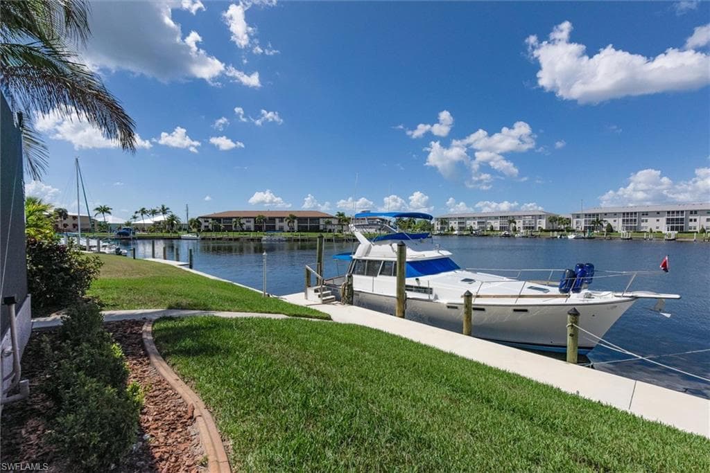 Dock featuring a lawn and a water view
