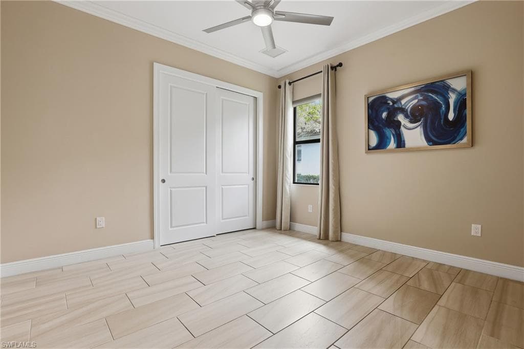 Unfurnished bedroom with crown molding, a ceiling fan, and a closet