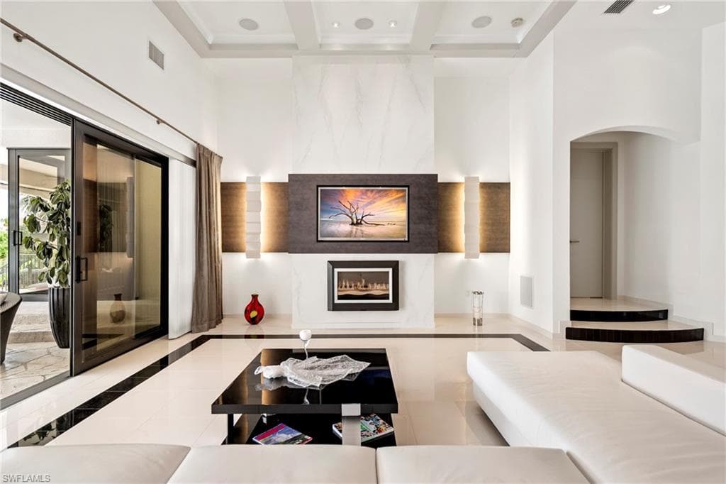 Sunken living room featuring inlaid floor details, a fireplace, recessed lighting, and coffered ceiling