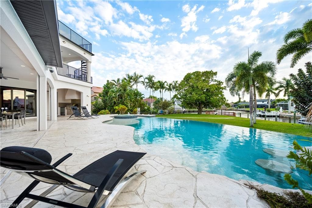 Combined pool / hot tub featuring a patio area and a balcony