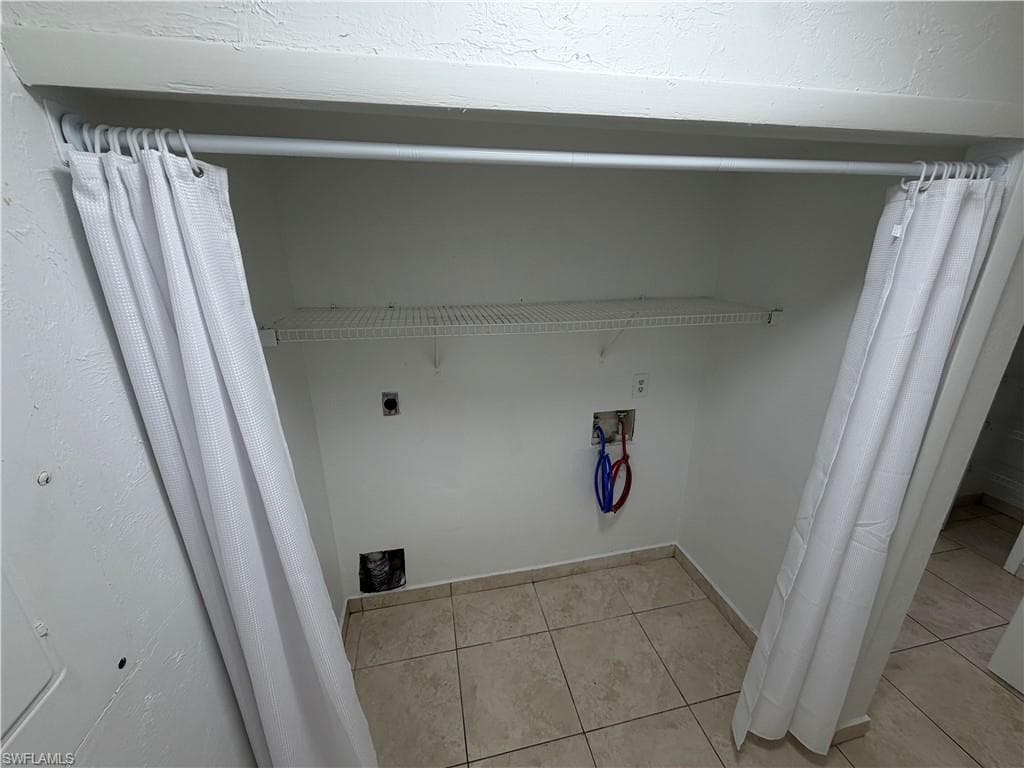 7374 Laundry area featuring washer hookup, light tile patterned floors, and electric dryer hookup