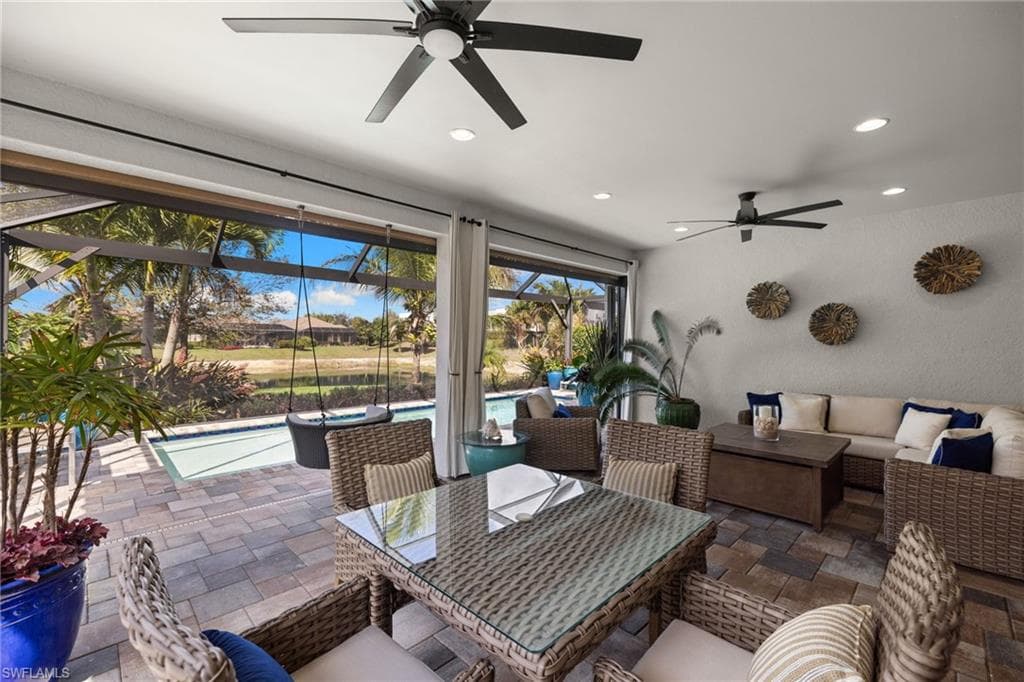 View of patio with an outdoor pool, a ceiling fan, outdoor seating, a sunroom, and a lanai