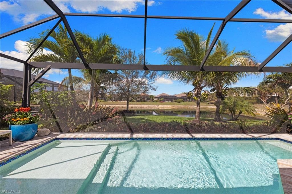 Outdoor pool featuring a sunroom, a water view, and a lanai