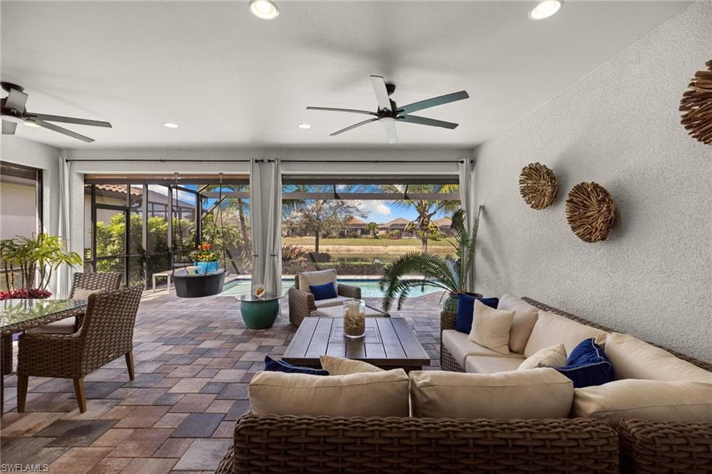 View of patio featuring an outdoor hangout area, a ceiling fan, glass enclosure, and a sunroom