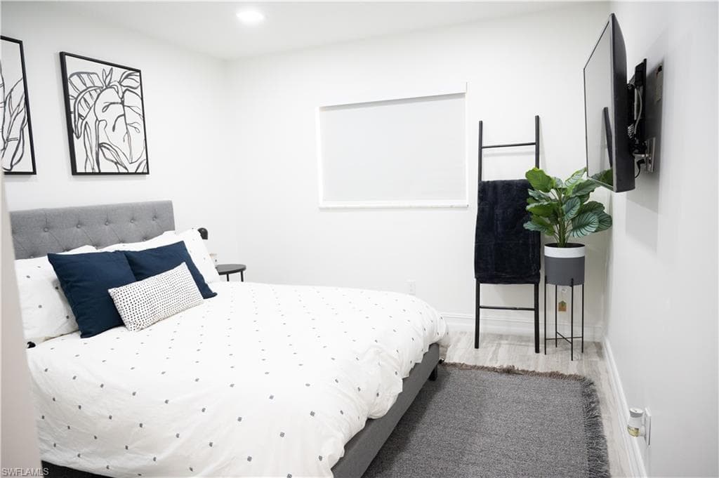 Bedroom with wood finished floors and recessed lighting