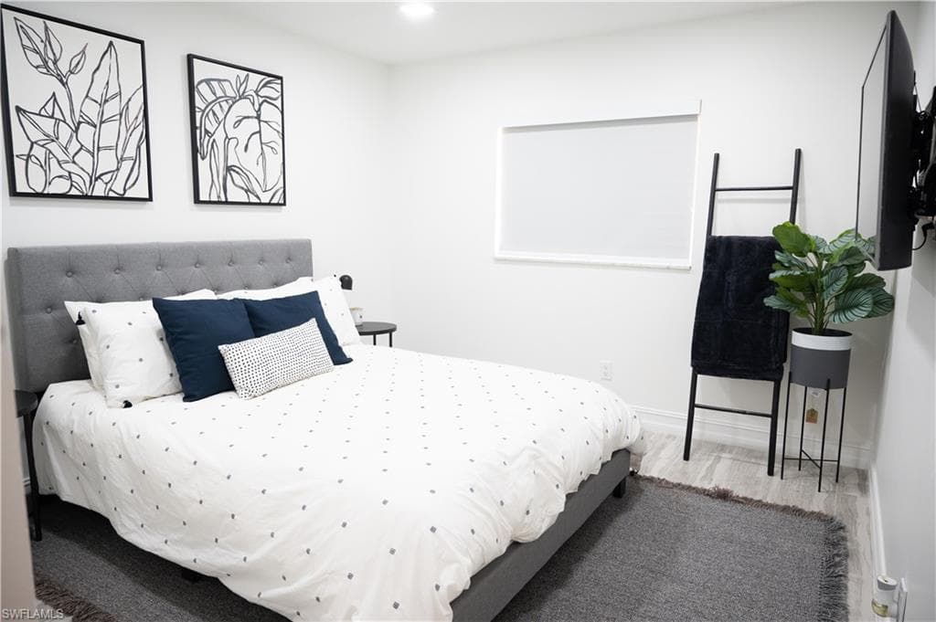 Bedroom with wood finished floors and recessed lighting