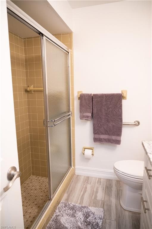 Bathroom featuring vanity, a shower stall, and light wood-style floors