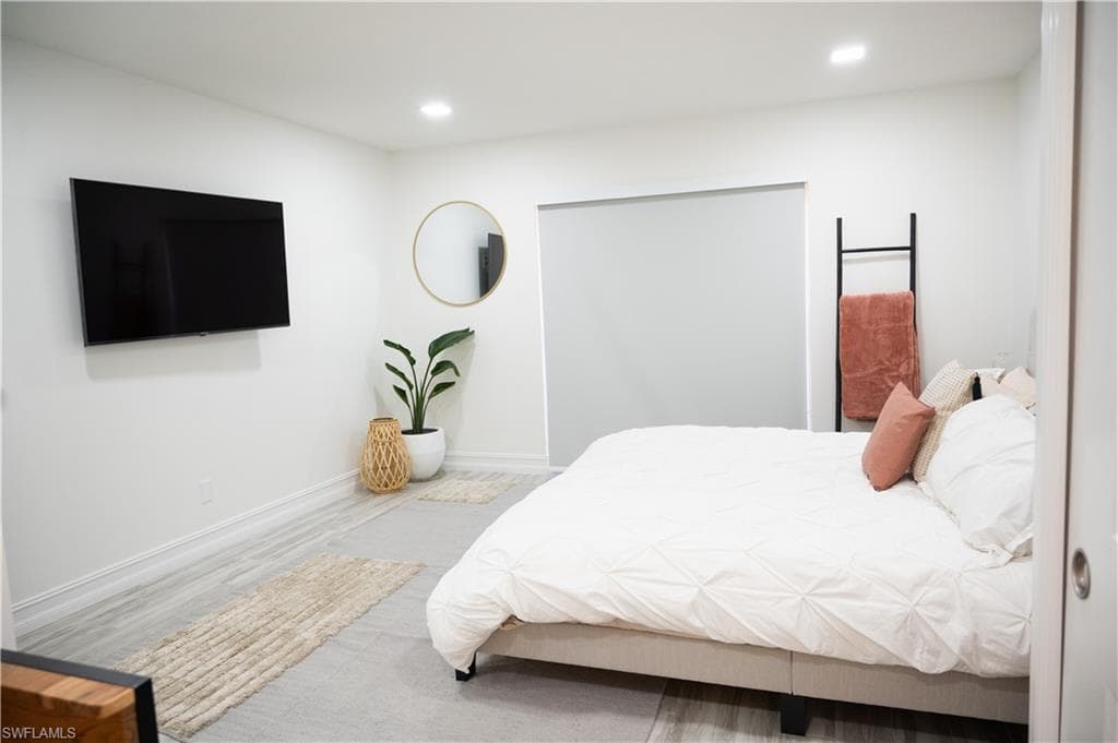 Bedroom with wood finished floors and recessed lighting