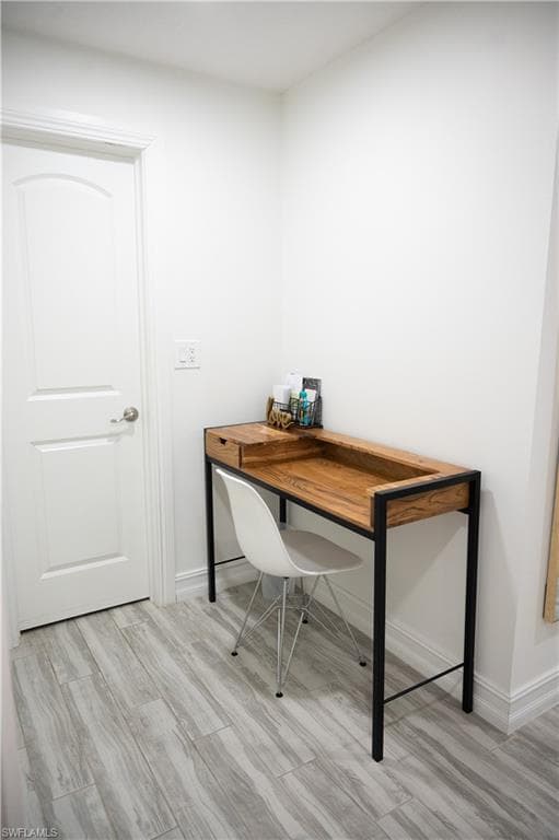 Home office featuring light wood-style floors and baseboards