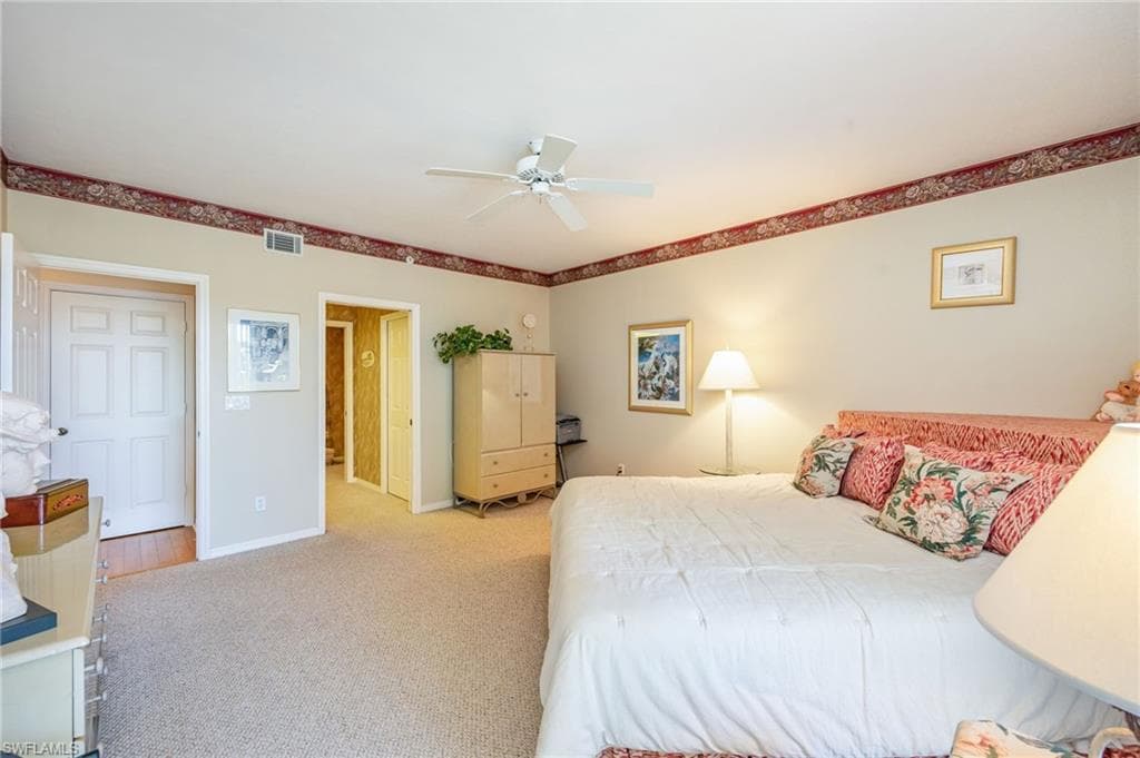 Carpeted bedroom with baseboards and a ceiling fan