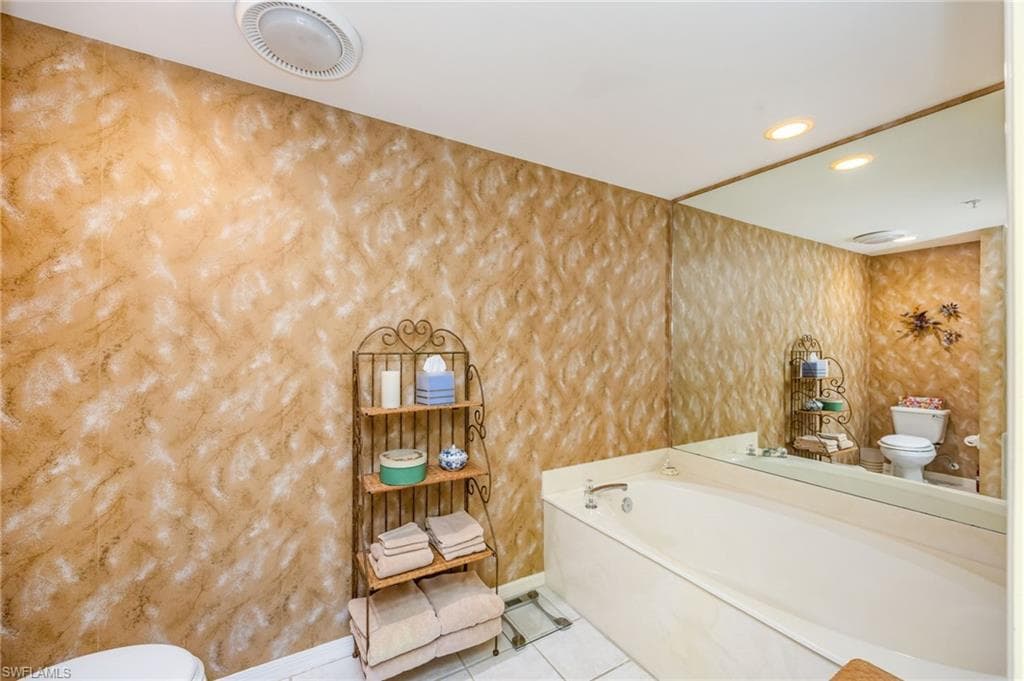 Bathroom featuring light tile patterned floors, a garden tub, and recessed lighting